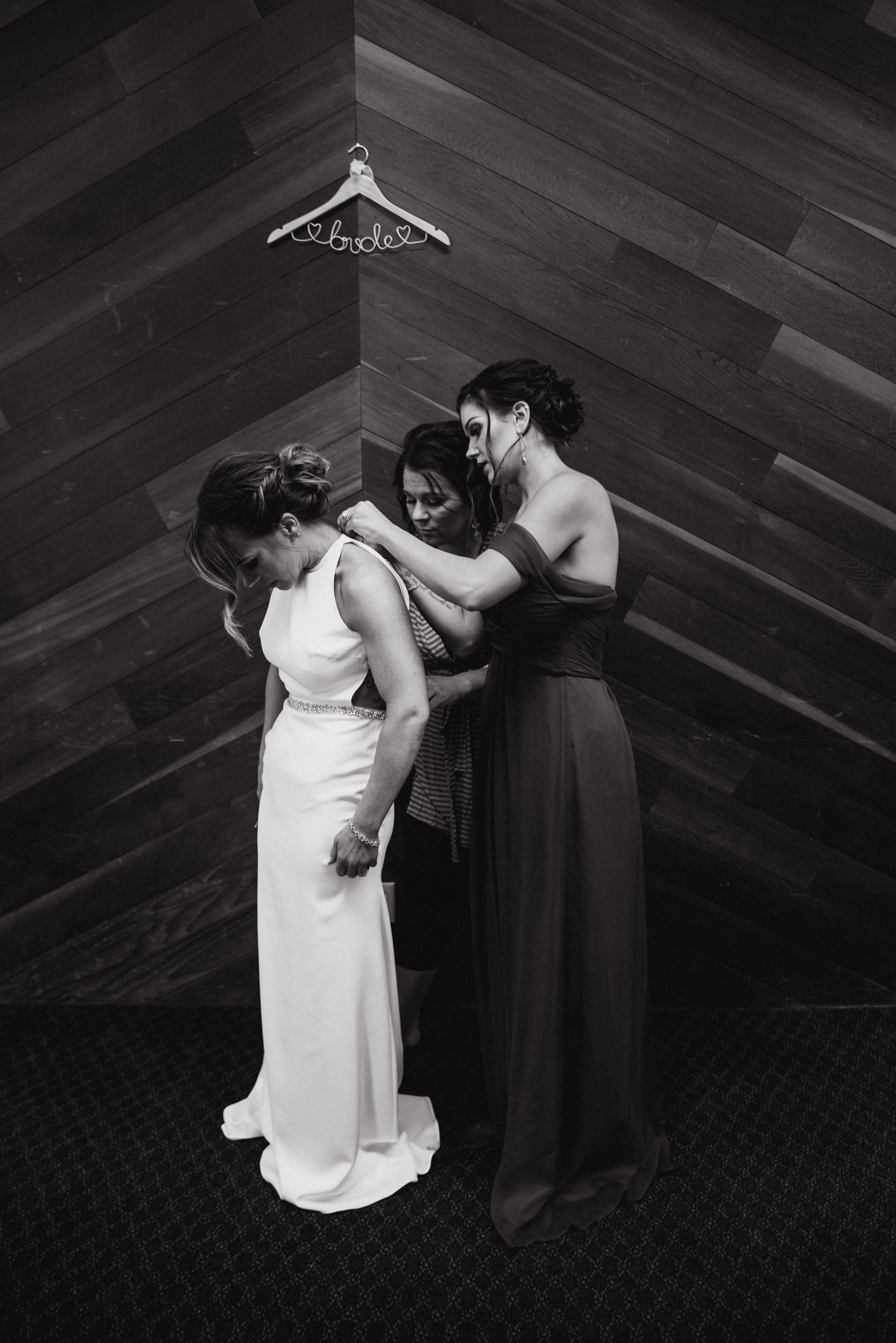 Bridesmaids helping bride into dressat a Romantic Style San Diego Wedding at Marina Village by Kylie Rae Photography